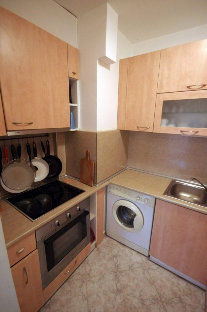 The fully equipped kitchenette in Apartment 1 with a sink, microwave, fridge, washing machine, stoves, oven and all necessary tableware and dinnerware.