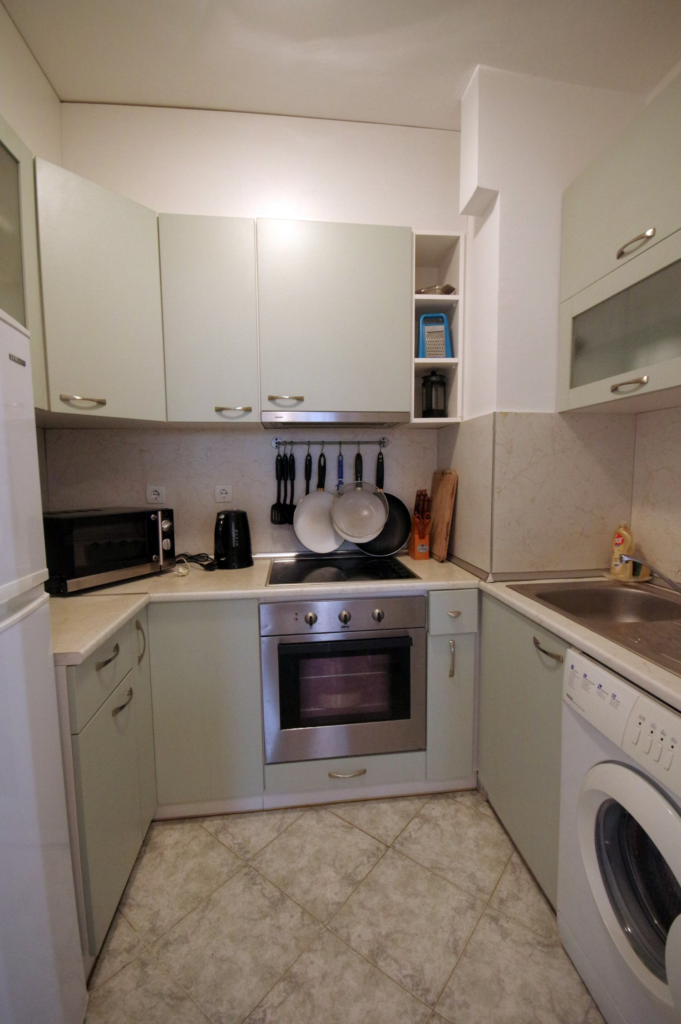 The fully equipped kitchenette in Apartment 2 with a sink, microwave, fridge, washing machine, stoves, oven and all necessary tableware and dinnerware.