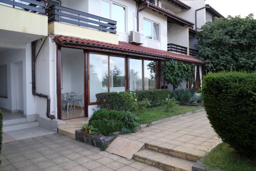 The outside complex space of Summer Romantica Apartment 2, with a nice green path in front of the patio space.