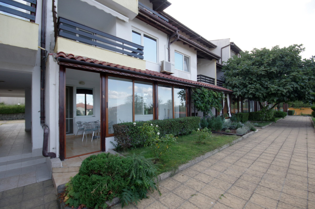 The outside complex space of Summer Romantica Apartment 2, with a nice green path in front of the patio space.