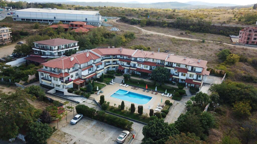 A Birds Eye view of Summer Romantica Apartments and the complex space they are located at. Shows the big private pool area that includes a children's pool, lounge chairs, and the private parking space.