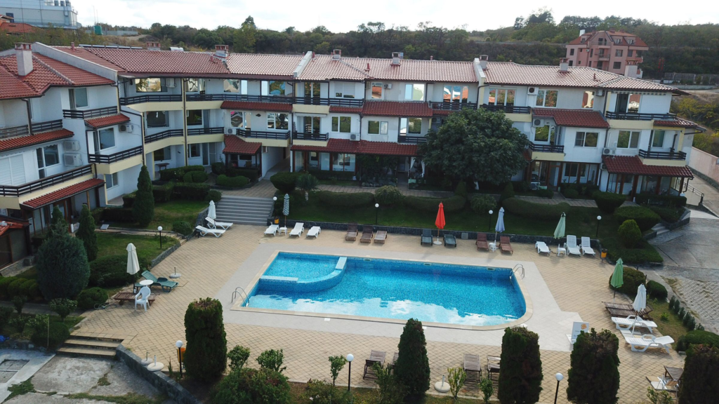 A Birds Eye view of Summer Romantica Apartments and the complex space they are located at. Shows the big private pool area that includes a children's pool, lounge chairs, and the private parking space.