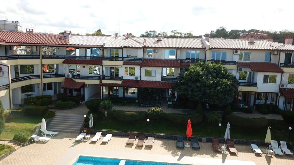 A Birds Eye view of Summer Romantica Apartments and the complex space they are located at. Shows the big private pool area that includes a children's pool, lounge chairs, and the private parking space.