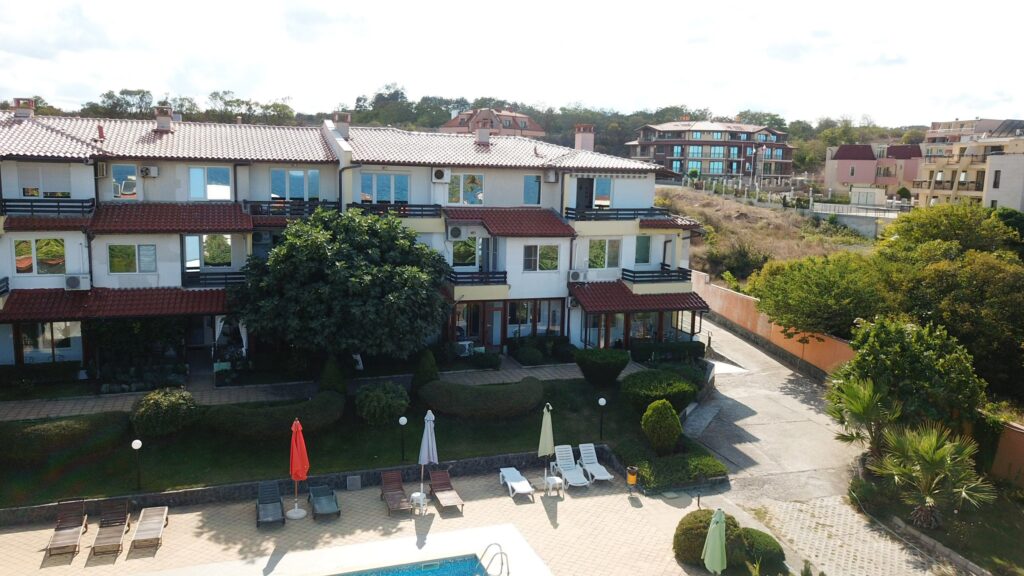 A Birds Eye view of Summer Romantica Apartments and the complex space they are located at. Shows the big private pool area that includes a children's pool, lounge chairs, and the private parking space.