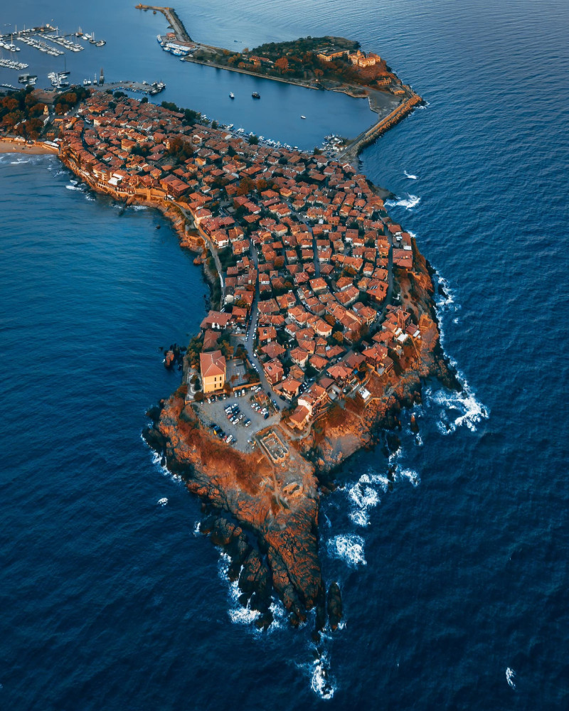 A birds eye view of part of Sozopol that is formed as a small peninsula and has a port.
